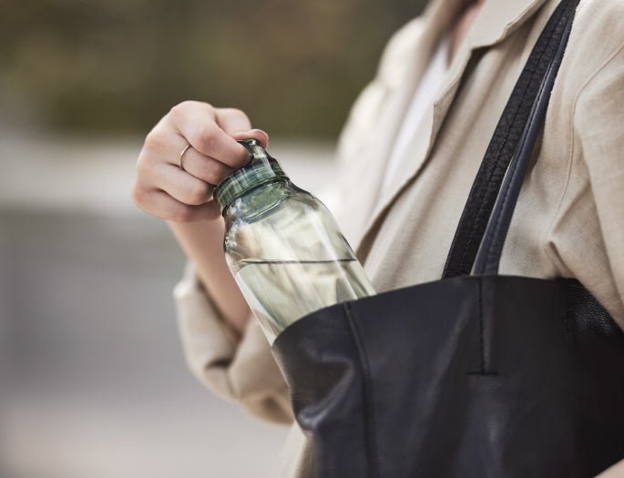 Person holding a water bottle with a blurred background